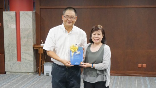 Editor principal, Dr. Wu Zhiliang, oferece o Livro Azul à Chefe da Divisão de Desenvolvimento de Recursos de Livros do Instituto Cultural, Dra. Kong Fan Teng